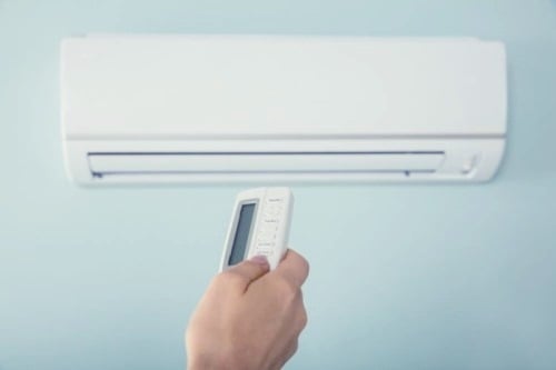 A person is turning on an air conditioning