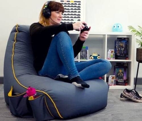 A girl is sitting on the chair and playing PS