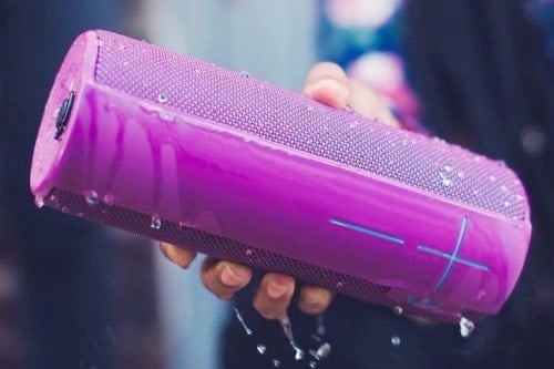 A person is holding a portable speaker