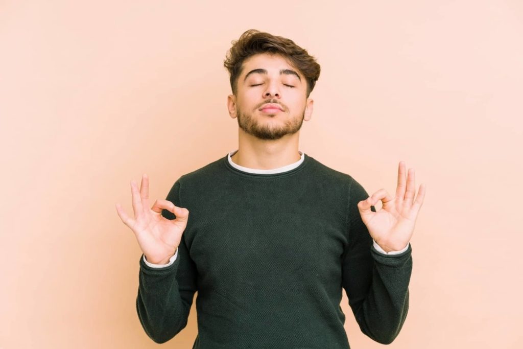 A man is meditating and trying to get relaxed